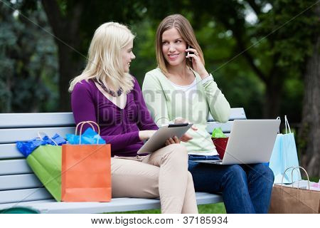 Compras mujeres usando la tableta Digital, ordenador y teléfono móvil en la banca.