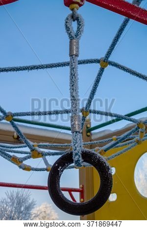 Children Playground Attraction In Winter Frost On Blue Sky Background