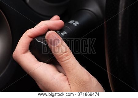 Close-up Female Hand Switches The Turn Signal Lever, Turns On Lighting, Selective Focus. Road Safety