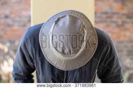 young man with a hat pointing down, gobo light window in the background, 