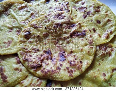 Closeup Of Yellow Color Traditional Dal Obbattu Or Holige In A Plate Isolated On White Background