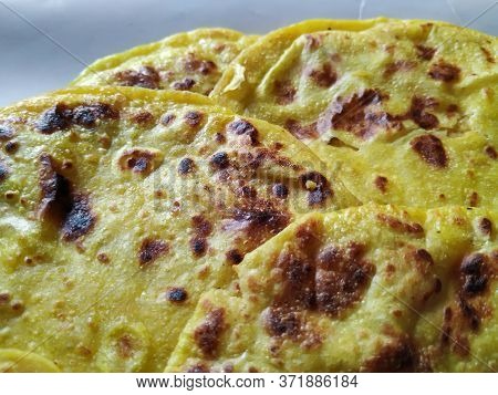 Closeup Of Yellow Color Traditional Dal Obbattu Or Holige In A Plate Isolated On White Background