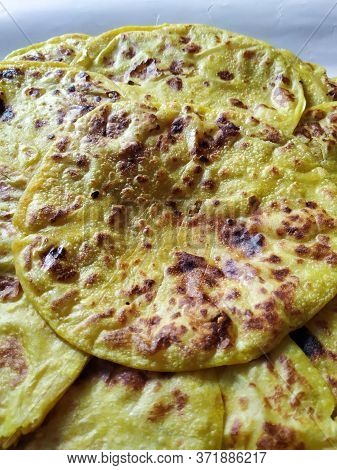 Closeup Of Yellow Color Traditional Dal Obbattu Or Holige In A Plate Isolated On White Background