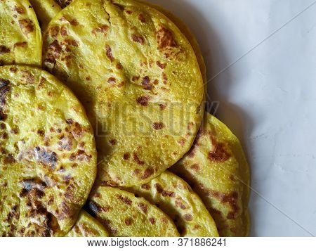 Closeup Of Yellow Color Traditional Dal Obbattu Or Holige In A Plate Isolated On White Background