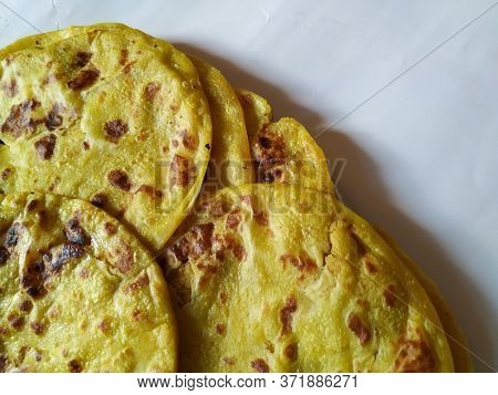 Closeup Of Yellow Color Traditional Dal Obbattu Or Holige In A Plate Isolated On White Background