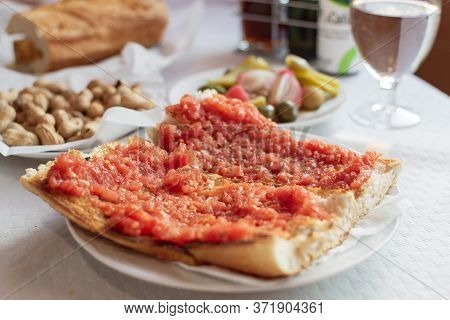 A Toast With Tomato Oil Peanuts And Olives