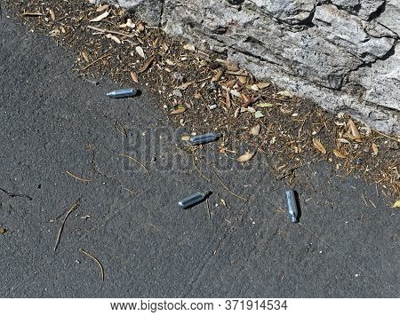 Empty Nitrous Oxide Canisters Discarded On A Pavement In Weston-super-mare, Uk