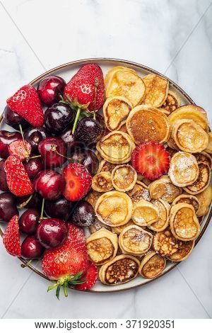 Trendy Home Breakfast With Tiny Cereal Pancakes And Fresh Strawberries And Cherries In The Plate. Vi