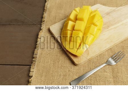 Yellow Half  Mango With Small Fork. Mango Fruit Cubes On The Wooden Table. Tropical Fruit Asia. Fres