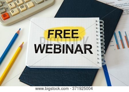 Desktop With Documents, Calculator And Notebook. On A Blockboard Inscription Free Webinar