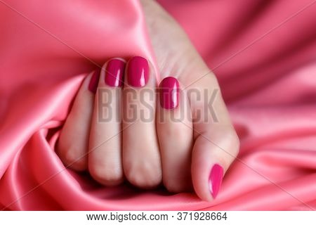 Female Hand With Pink Manicure On A Background Of Pink