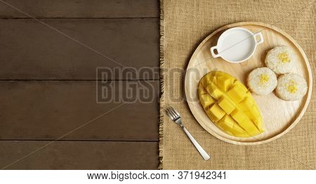 Top View Yellow Half  Mango With Small Fork. Mango Fruit Cubes On The Wooden Table. Tropical Fruit A