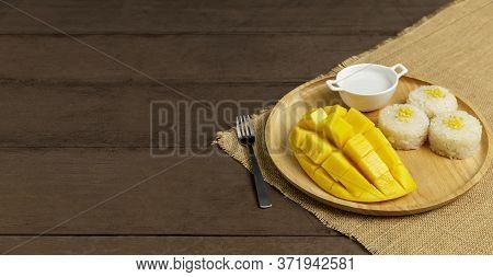 Yellow Half  Mango With Small Fork. Mango Fruit Cubes On The Wooden Table. Tropical Fruit Asia. Fres