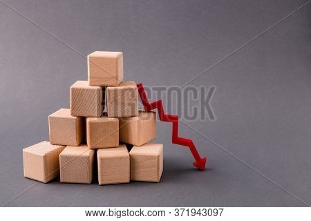 Photo Of Pile Stack Pyramid Wooden Cubes Market Supply Sales Falling Down Arrow Pointing Zero Income
