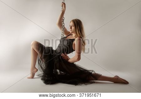 Slender Girl Dancing With A Large Chain In An Incredible Ballerina Pose