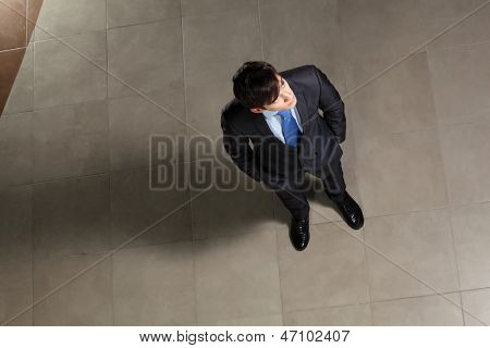 Image of young businessman looking above. Top view