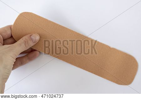 Woman Is Holding A Piece Of Beige Kinesiotape. Kinesio Tape Can Help You Prevent Injuries And Heal F