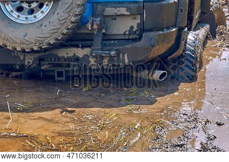 Rear View Of A Blue 4x4 Off-road Car Stalling In A Swamp During Extreme Competitions. Off-road Car R