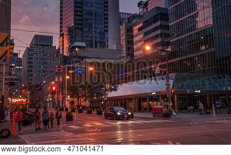 Toronto, Canada - 07 01 2022: Summer Night View Along Simcoe Street With People And A Car Waiting On