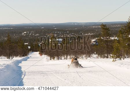 Unrecognizable People Sledding Down A Tobogganing Run In Lapland. Saariselka