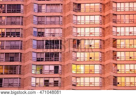 Urban Geometry. Rows Of Large Windows With Various Curtains, Shutters, Blinds, Jalousies In A Bricky