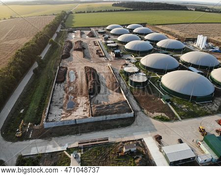 Biogas Complex On Nature Landscape. Agricultural Plant For Biomass Production On Green Field. Modern
