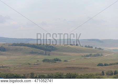A View Of A Hilly Area With A Road Running Through It, Hills On Background