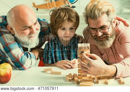Male Generations Friendship. Grandfather Teaching Grandson How To Play Jenga Games. Men Family. Thre