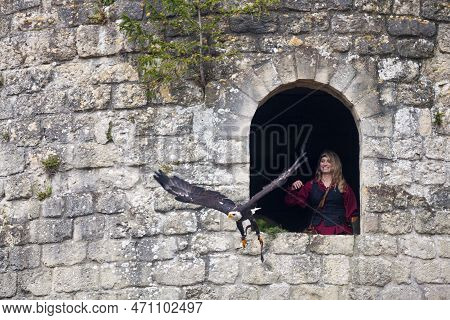 Luzarches, France - October 12 2019: Falconer Up In A Donjon With Her Bald Eagle During The Annual '