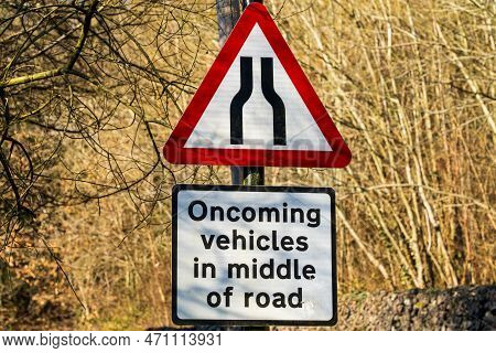 Uk Traffic Sign Stating Road Narrows Ahead And Oncoming Wehicles Will Be In The Middle Of The Road O