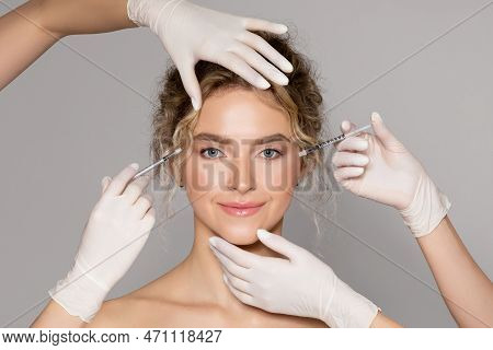 Attractive Young Woman Getting Injection For Eyes Area By Two Cosmetologists Giving Anti Aging Serum