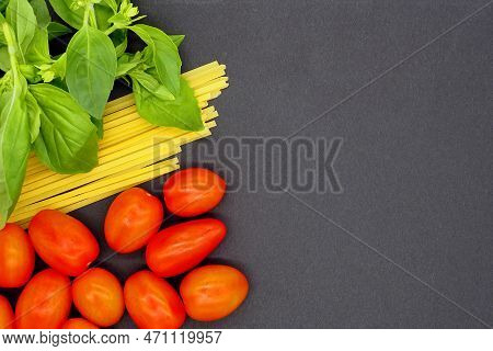 Pasta Tallarines, Basil And Tomatoes Cherry On Black Background. Flat Lay. Copy Space.