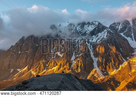 Scenic Landscape With Snowy Mountain Top In Low Clouds In Golden Sunrise Colors. Colorful View To Sn