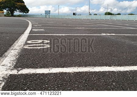 Empty Parking Lot - Numbered Parking Spaces In Drive-in - Rugged Asphalt