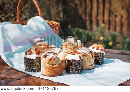 Easter Baking On A Wooden Table In A Spring Garden. A Lot Of Pastries On The Table Next To A Basket