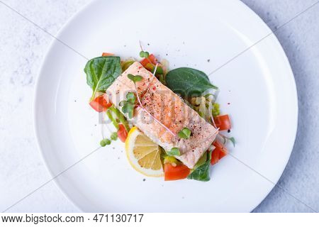 Trout (salmon) With Vegetables, Lemon And Microgreens, Cooked By The Confit Method. Traditional Fren