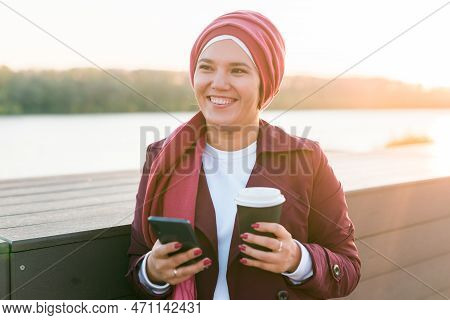 Modern Arab Girl In Hijab Walking By Street And Drinking Coffee Take Away In Spring Time Morning