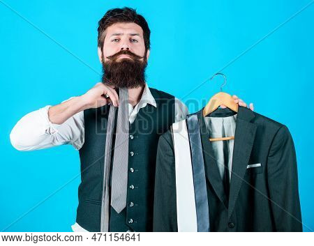 How About This Tie. Brutal Hipster Holding Colorful Tie Collection And Suit Jacket. Bearded Man Matc
