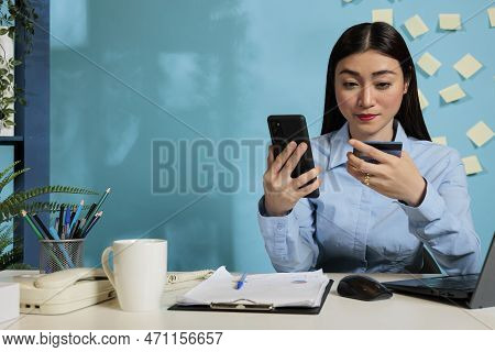 Asian Businesswoman Talking To Bank Customer Service To Report An Erroneous Charge On Her Bank State