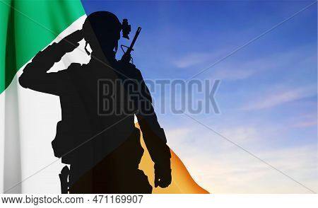 Silhouette Of A Saluting Soldier On Background Of Irish Flag Against The Sky. Concept - Armed Forces