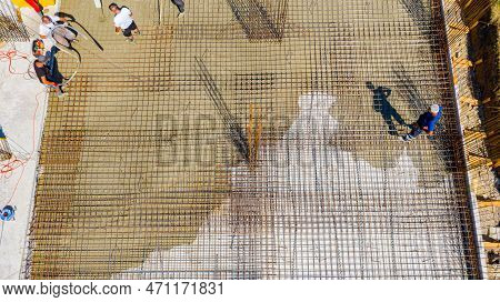 Aerial Top View Construction Worker Is Directing The Pump Tube As Pouring Layer Of Concrete In Build