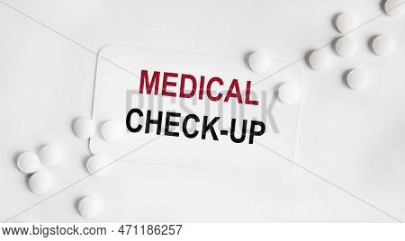 On The White Card Inscription Medical Check-up, The Rdom Neatly Lined White Tablets. Medical And Hea