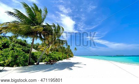 Paradise Beach With Empty Beach Chairs, White Sand, Deep Blue Sea And Blue Sky With White Clouds And