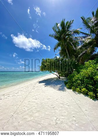 Sunny And Windy Day At The Beach With White Sand, Blue Sky With A Few Clouds And Clear Water, Green 