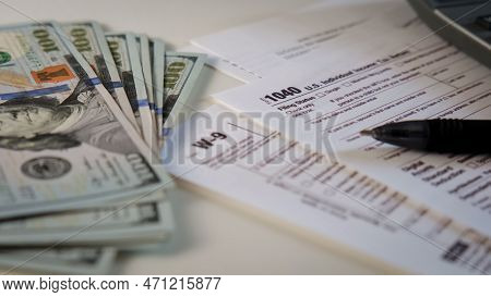 Close Up Of A 1040 And W9 Individual Tax Form Are Placed On Desk Of American Citizen.
