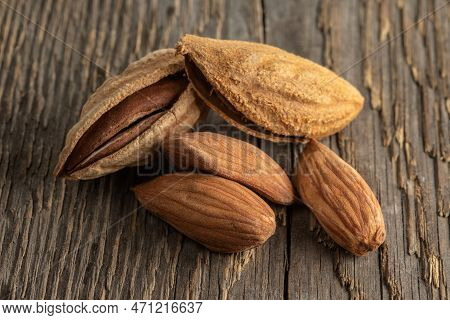 Inshell Almonds On A Background Of Rough Wood Texture. Selective Focus.
