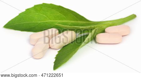 Adhatoda Vasica Or Medicinal Basak Leaves With Tablets Over White Background