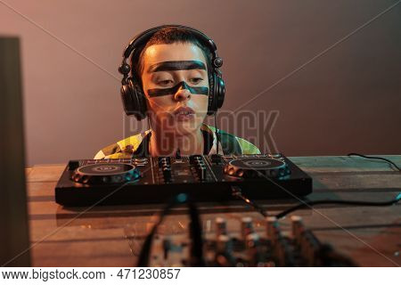 Female Artist Looking At Dj Turntables In Studio, Preparing To Mix Techno Music And Have Fun At Nigh