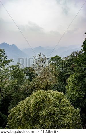 Mountainous Landscape In The Haze With Trees In The Foreground In Qingcheng Shan, Sichuan Province, 