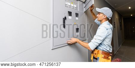 An Electrician Working On An Industrial Breaker Panel. Model Is An Actual Electrician Performing All